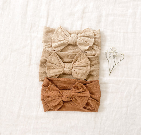 Frilly boho headband in soft fabric with a large bow, perfect for adding style to any outfit.