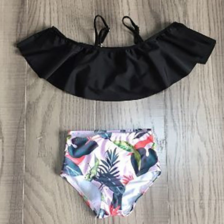 Girls 2 piece black ruffle pink tropical bikini featuring a light pink off-the-shoulder top and high-waisted tropical print bottom.