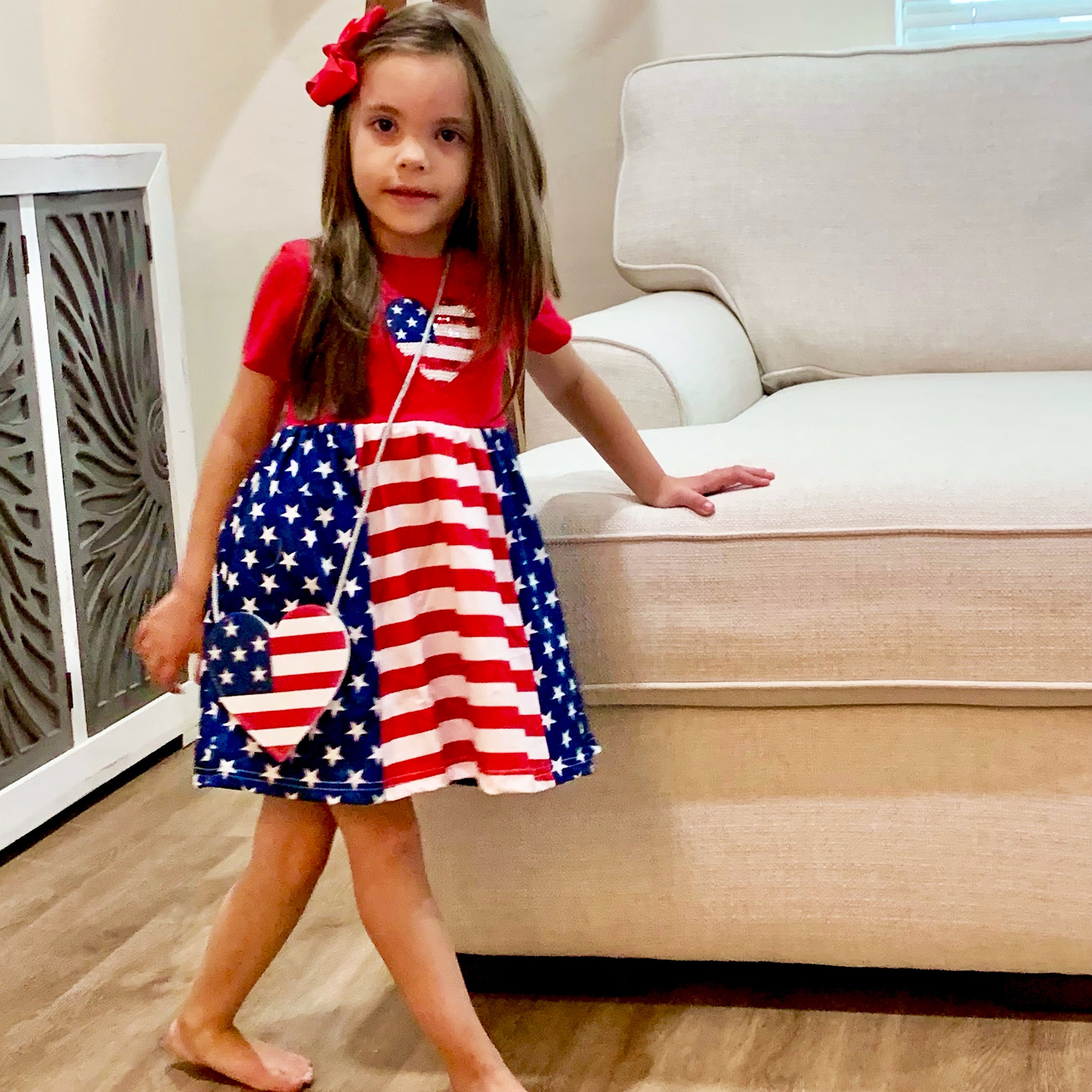 Girls 4th of July dress featuring red cotton top with sequined American Flag heart and Stars and Stripes skirt, accompanied by matching purse.