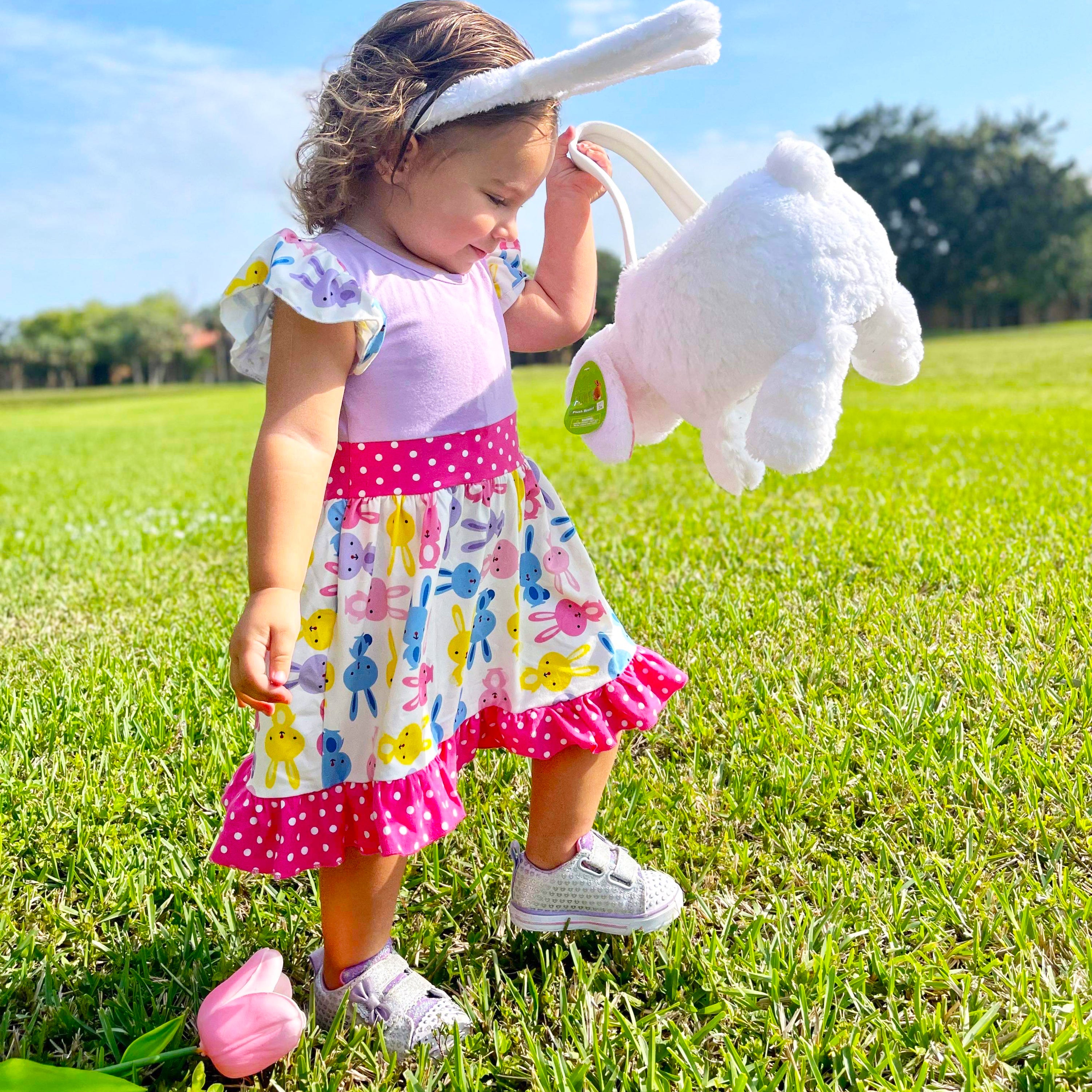 Girls Easter Bunny Dress featuring ruffles, angel cap sleeves, and a playful bunny print in pink and purple.