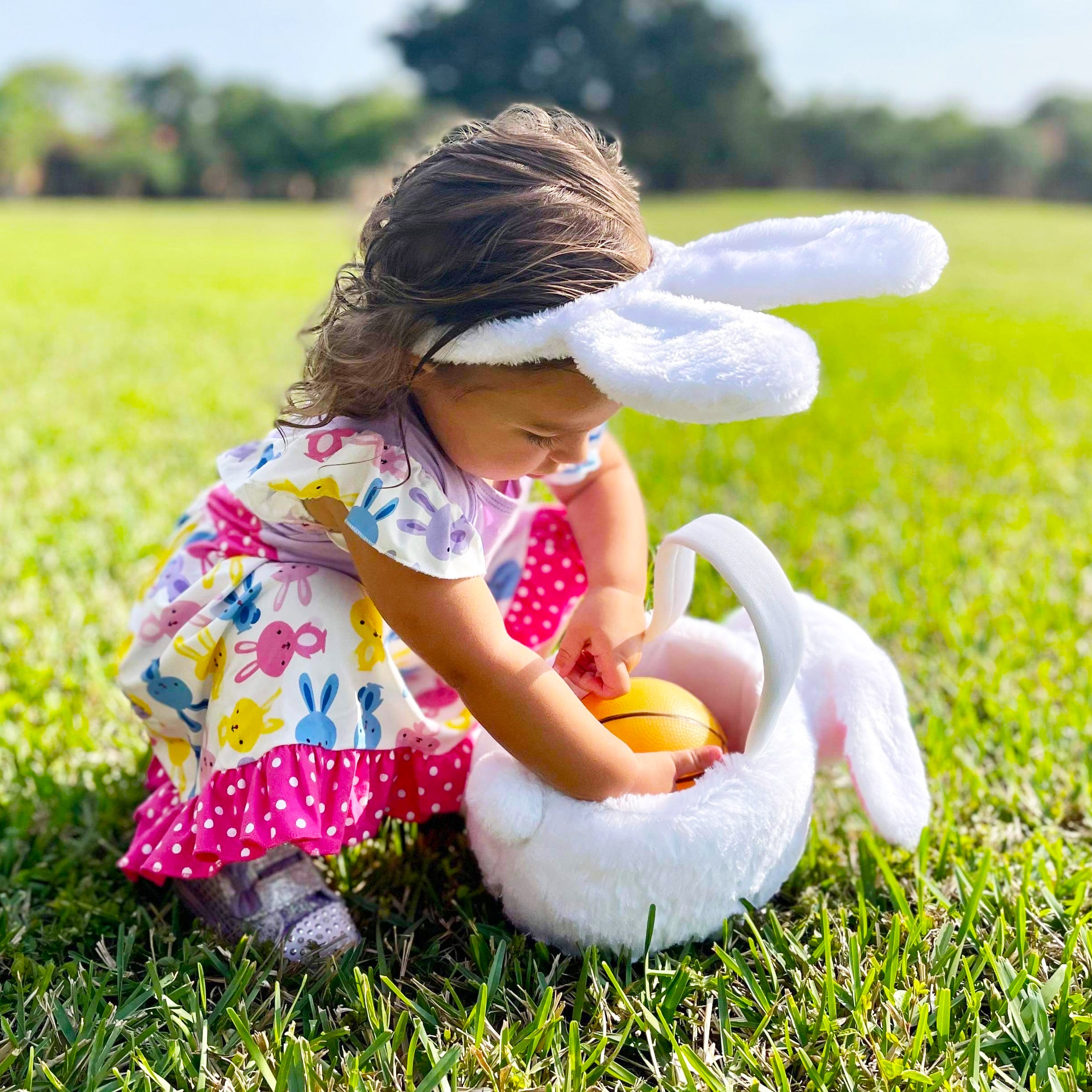 Girls Easter Bunny Dress featuring ruffles, angel cap sleeves, and a playful bunny print in pink and purple.