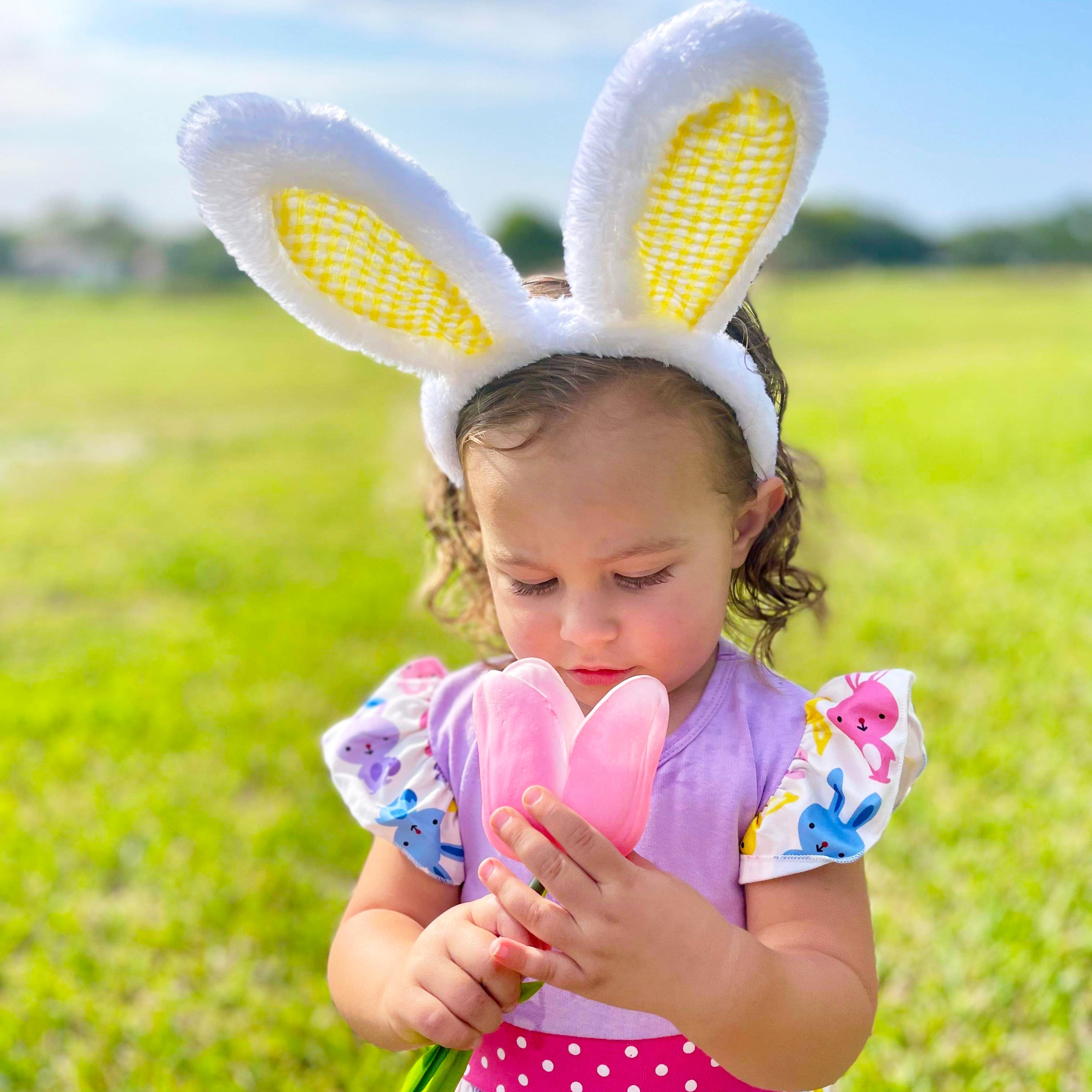 Girls Easter Bunny Dress featuring ruffles, angel cap sleeves, and a playful bunny print in pink and purple.