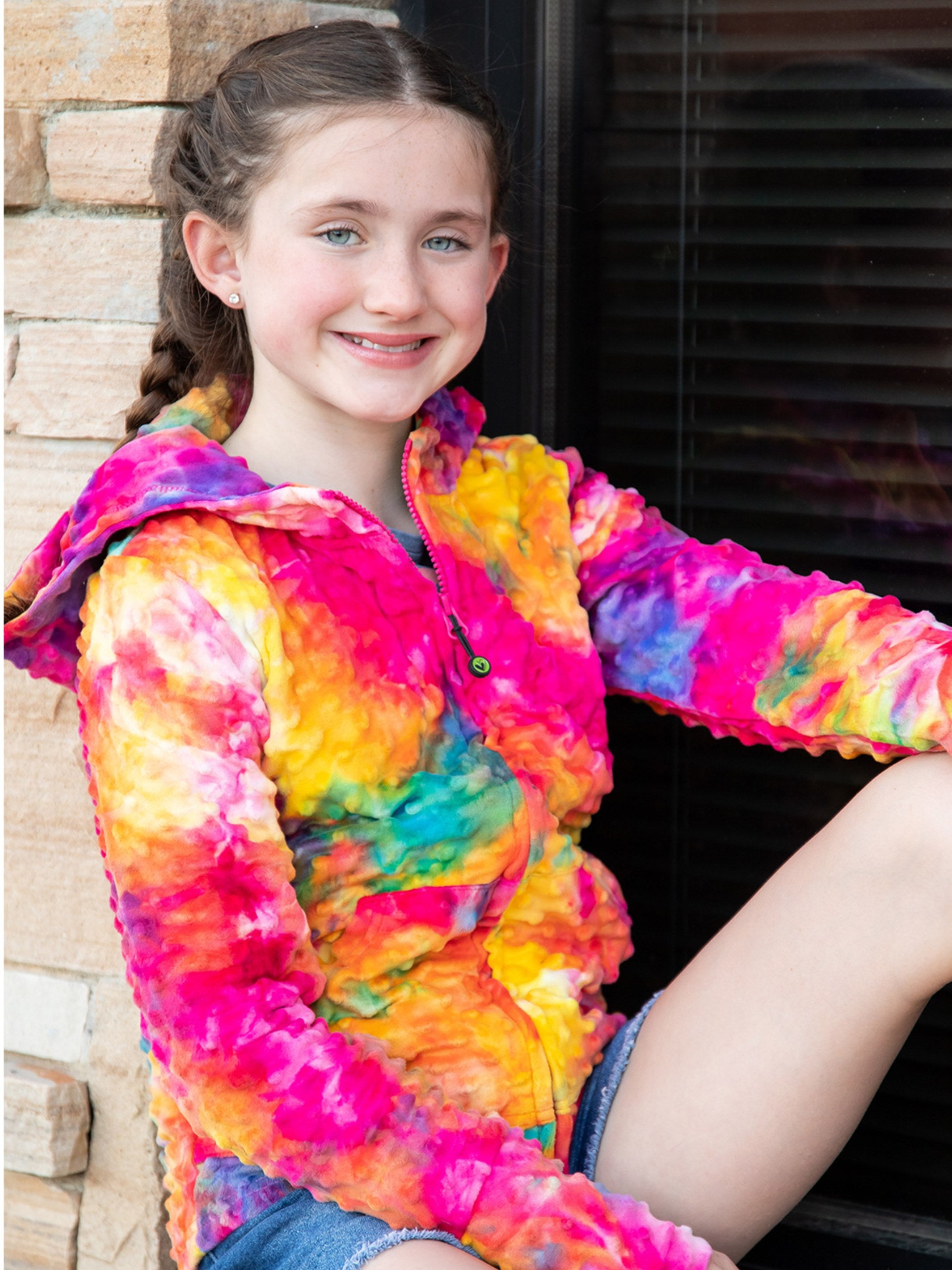 Bright Rainbow Tie Dye Girls Hoodie by Limeapple, featuring vibrant colors and a cozy design, perfect for layering and lounging.