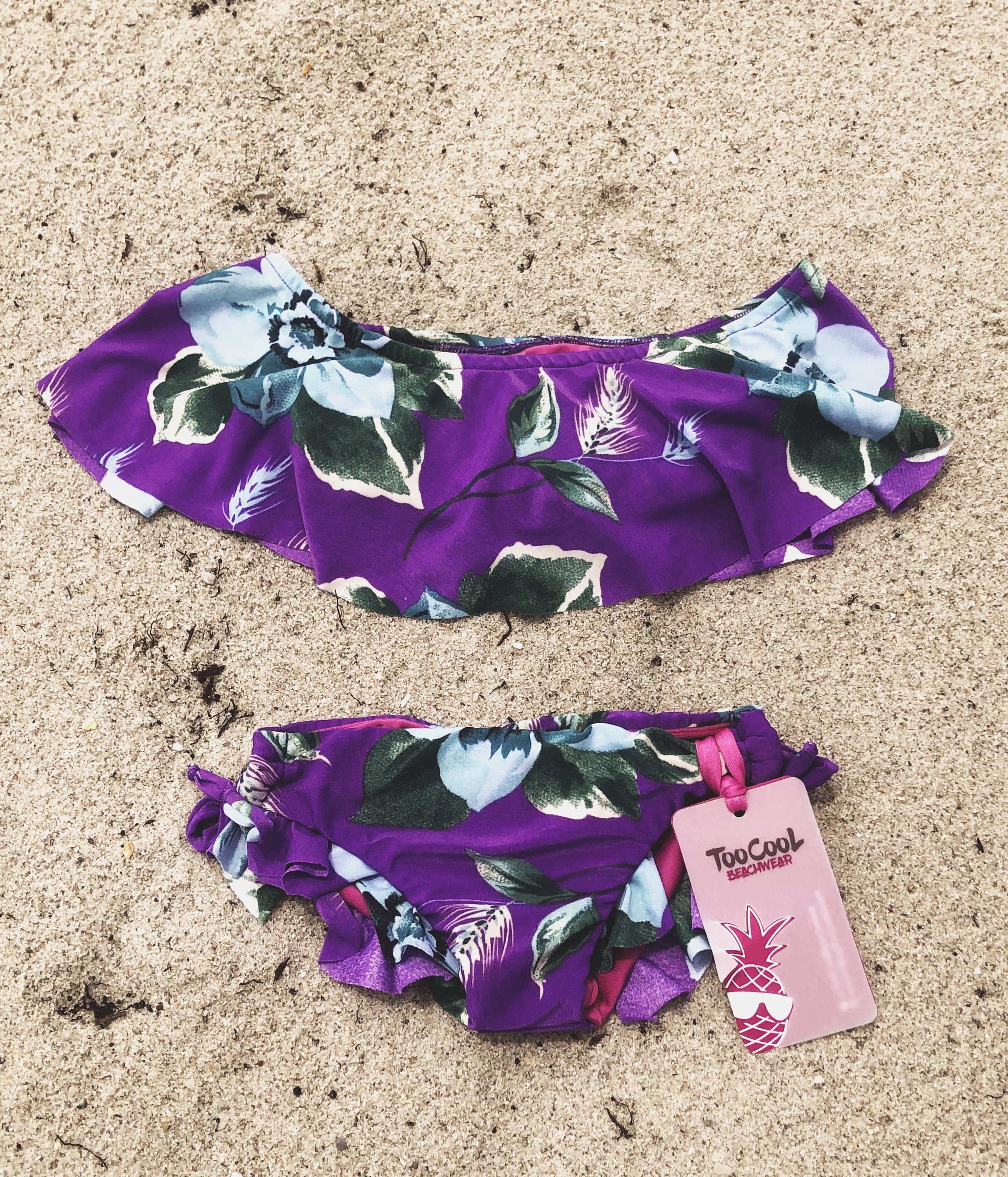 Vibrant green and purple off-shoulder bikini with adjustable lateral ties, perfect for summer fun.