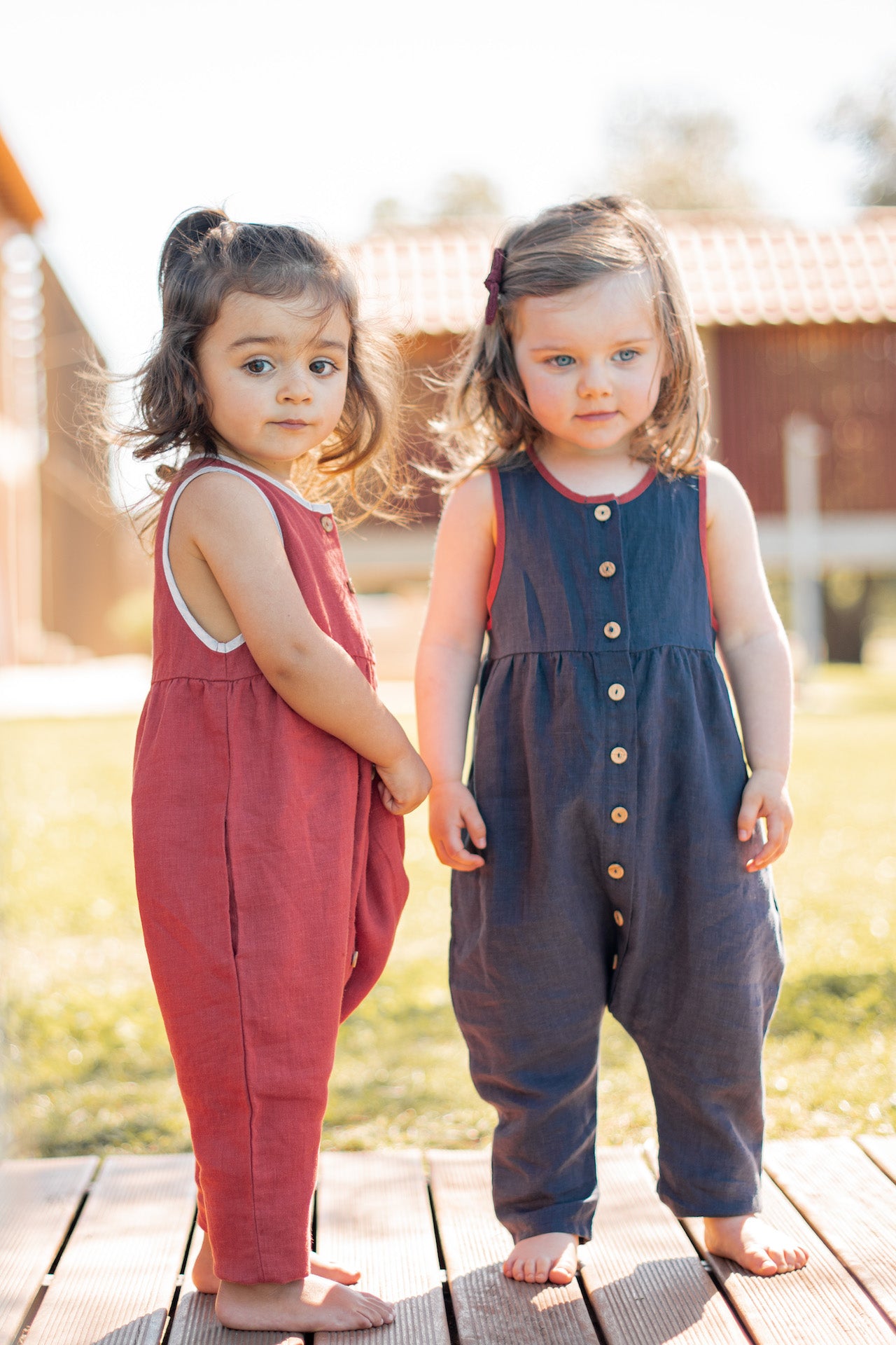 A stylish sleeveless jumpsuit in sun drop blue, featuring a contrast collar, olive wood buttons, and made from 100% linen fabric.