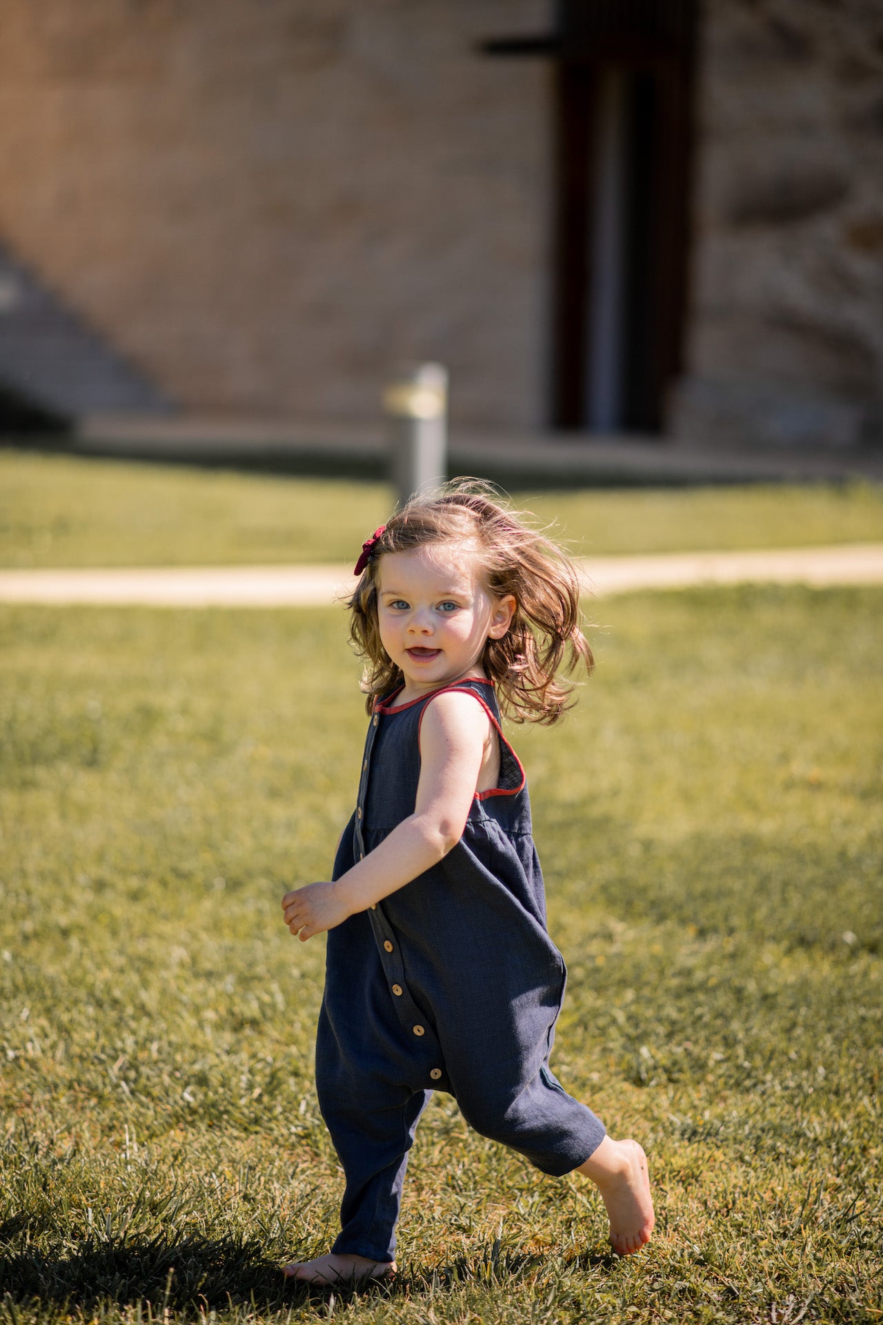 A stylish sleeveless jumpsuit in sun drop blue, featuring a contrast collar, olive wood buttons, and made from 100% linen fabric.