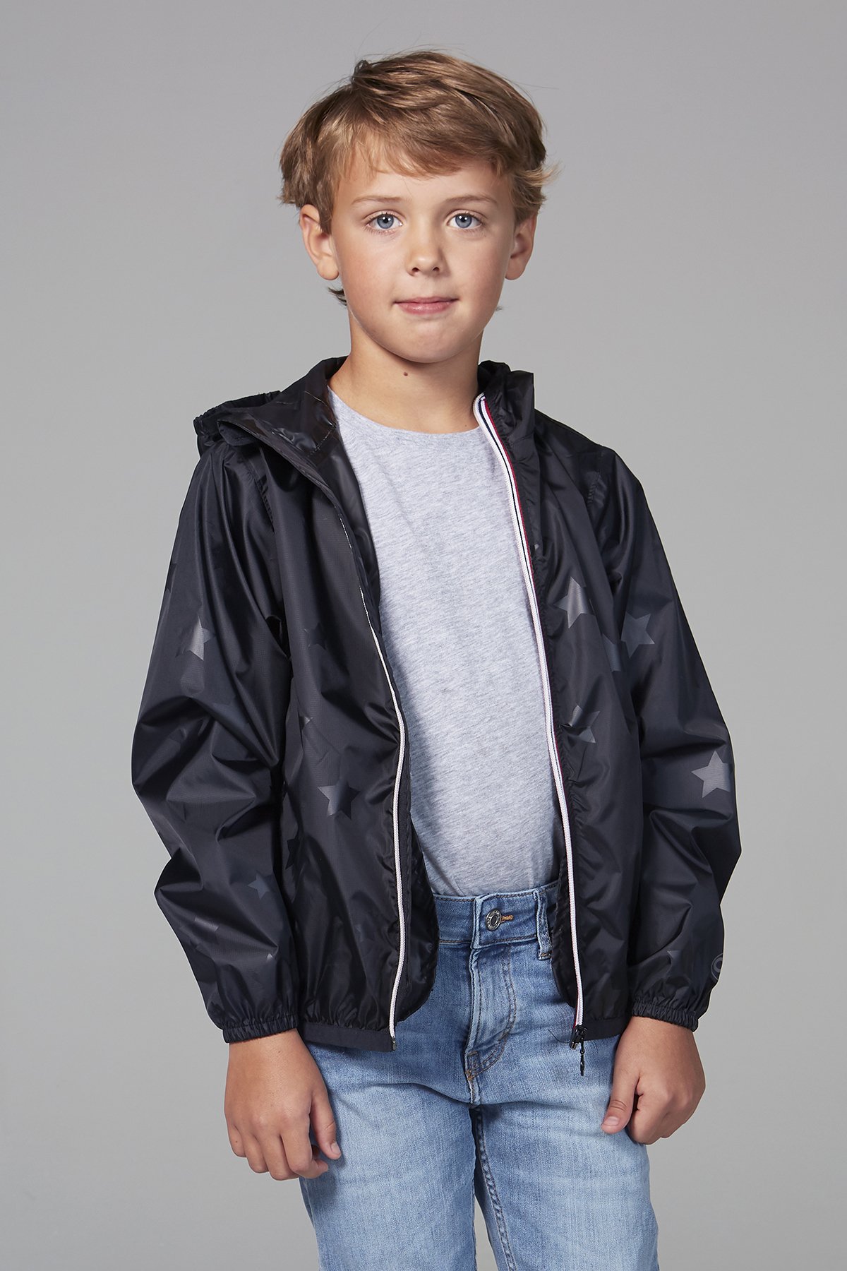 Kids black gloss stars packable rain jacket, showcasing its stylish design and practical features.