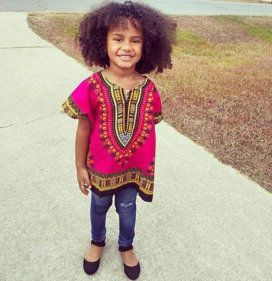 A vibrant pink Kids Dashiki shirt featuring traditional patterns, perfect for casual outings and playtime.