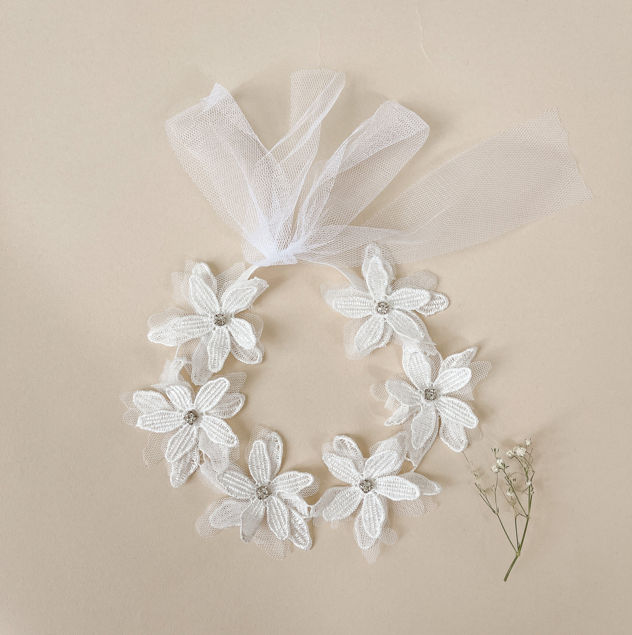 A stylish Lacey Flower headband featuring a delicate lace flower design, perfect for babies and toddlers aged 3M to 4T.