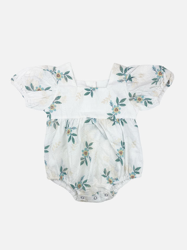 Maeve embroidered onesie featuring a white floral base with green flowers and cream embroidery, puff sleeves, and a snap crotch closure.