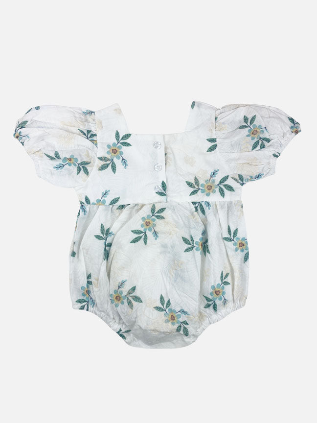 Maeve embroidered onesie featuring a white floral base with green flowers and cream embroidery, puff sleeves, and a snap crotch closure.