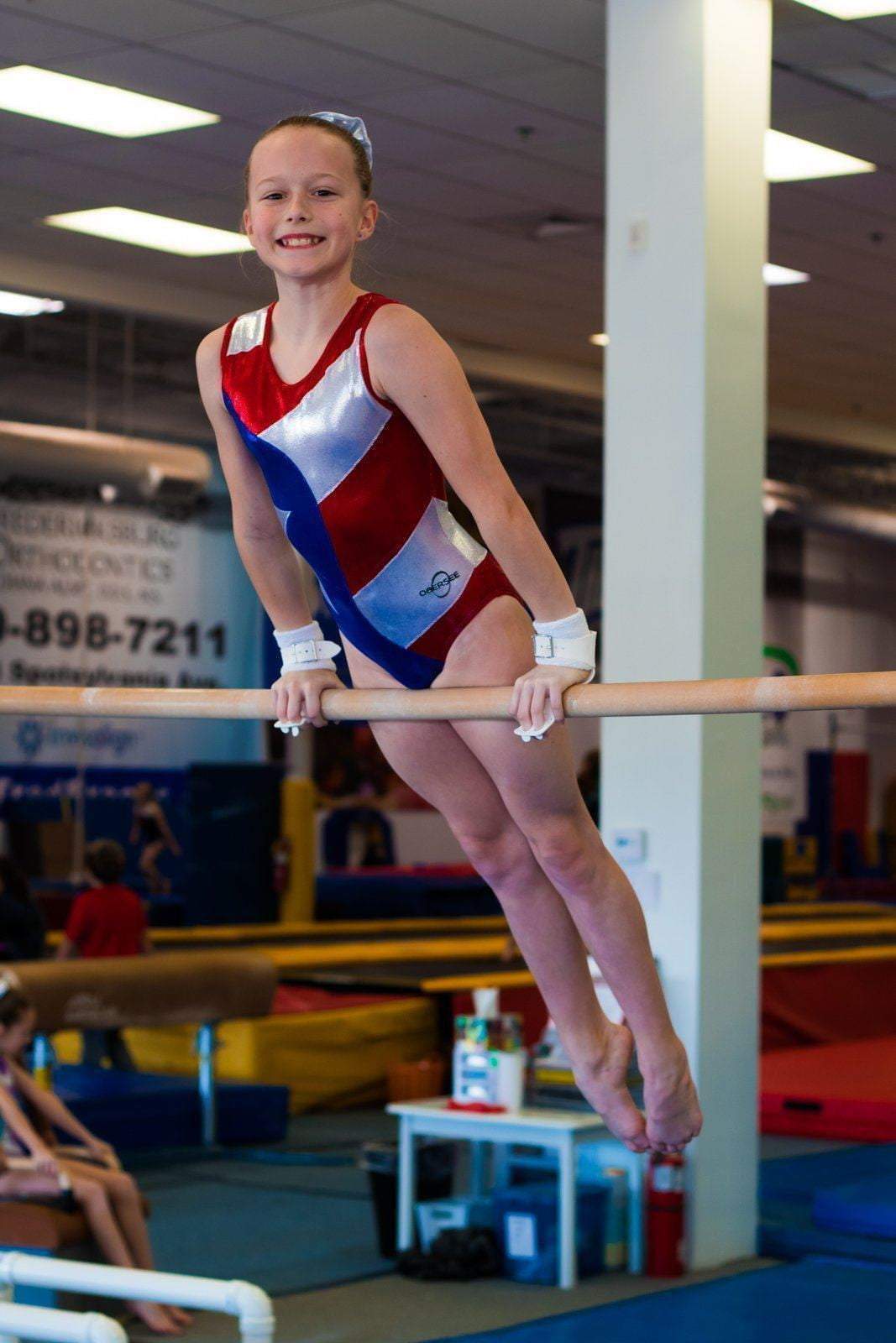 O3GL024 Obersee Girls Gymnastics Leotard in vibrant Flag Red, featuring a scoop neck design and shimmering fabric, perfect for gymnastics and dance.