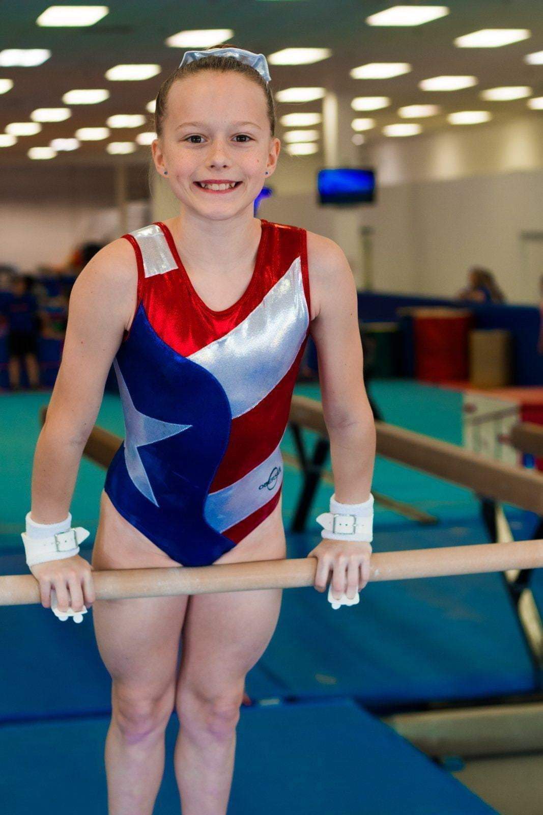 O3GL024 Obersee Girls Gymnastics Leotard in vibrant Flag Red, featuring a scoop neck design and shimmering fabric, perfect for gymnastics and dance.