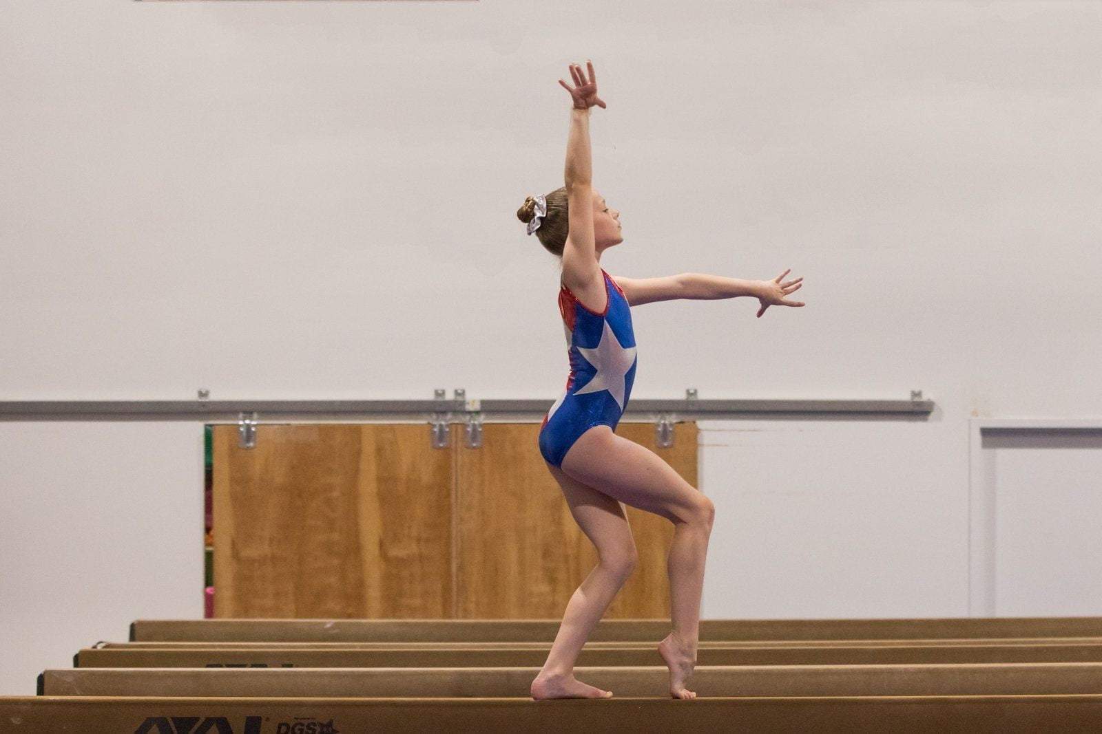 O3GL024 Obersee Girls Gymnastics Leotard in vibrant Flag Red, featuring a scoop neck design and shimmering fabric, perfect for gymnastics and dance.