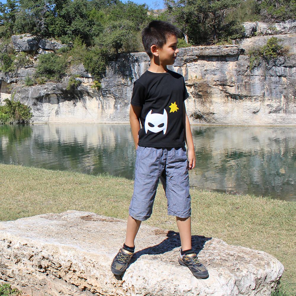 A vibrant Pow - Superhero Tee featuring colorful felt superhero appliqués, perfect for infants and toddlers, handmade with love.