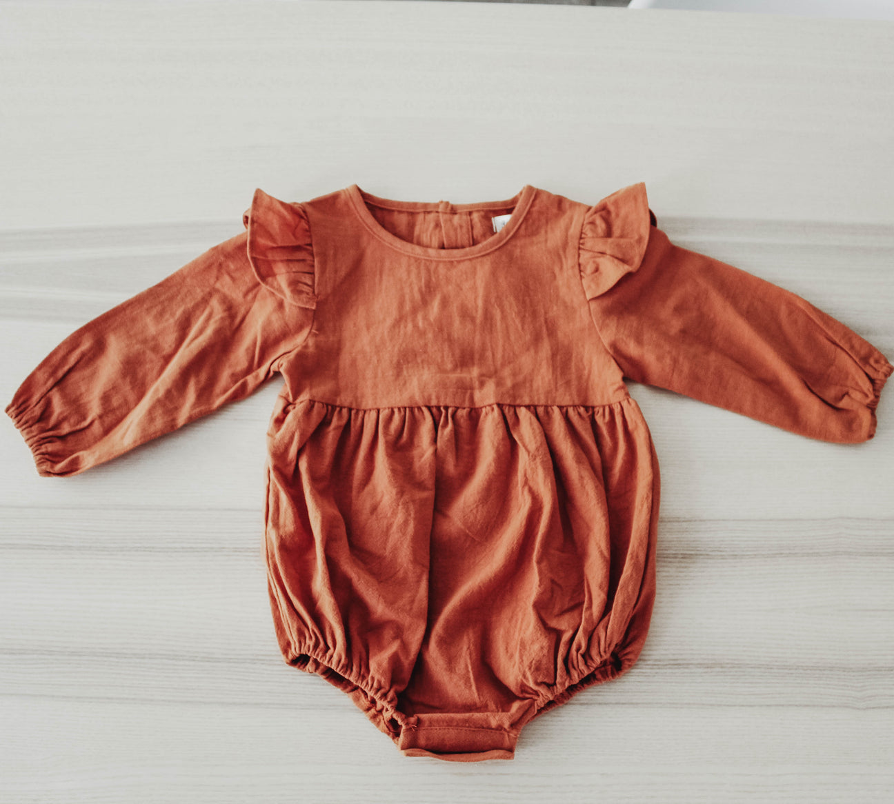 A stylish Prim Romper made from soft cotton, showcasing its comfortable fit and versatile design, perfect for casual wear.