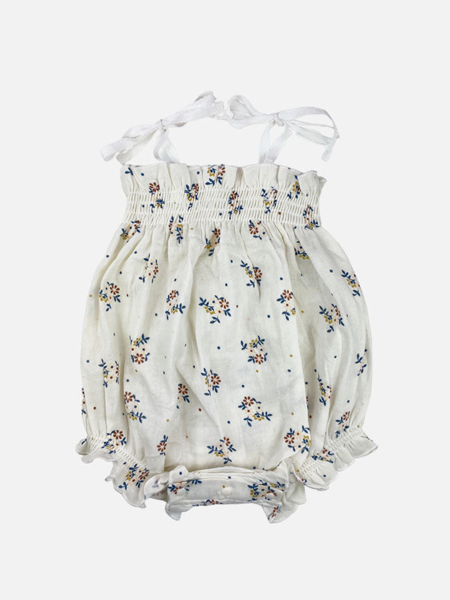 Quinn Ruffle Tie Onesie in cream floral, featuring ruffles and adjustable tie straps, perfect for babies.