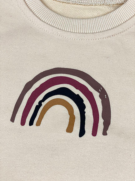 A cozy rainbow 2 pc sweatshirt set in toast color featuring a vintage rainbow design on the sweatshirt and bubble shorts with elastic waistband.