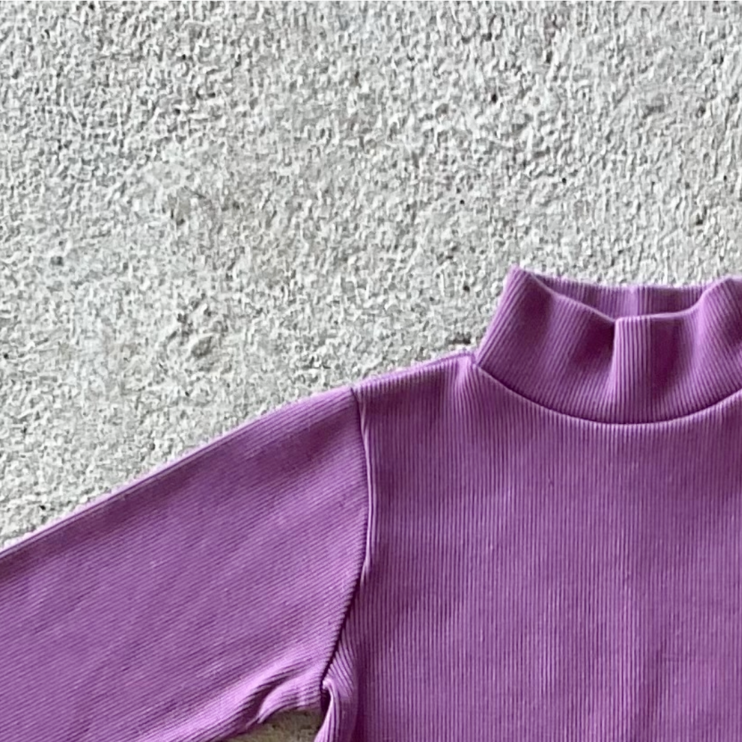 A vibrant orchid-colored ribbed long-sleeve shirt for kids with a turtle neck and round collar, made from 100% organic cotton.