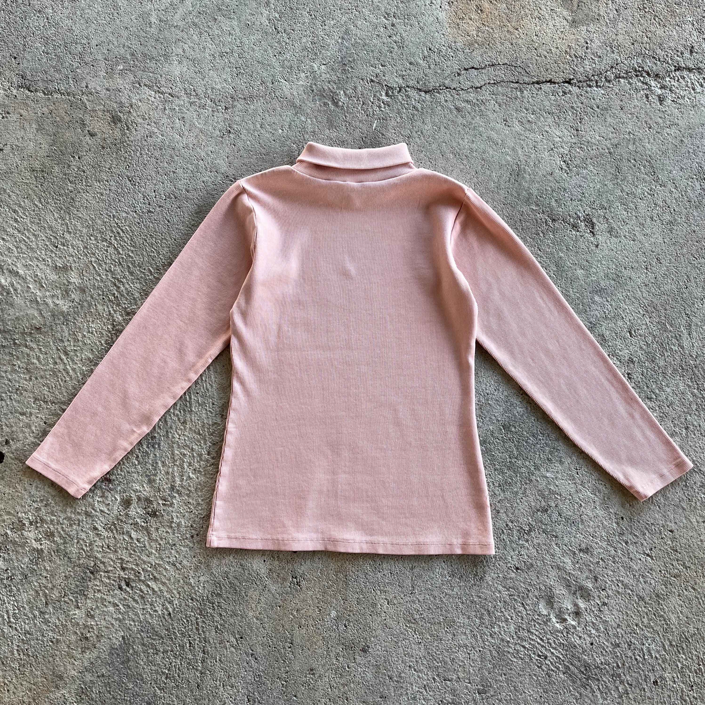 A pink ribbed long-sleeve shirt for kids with a turtle neck and round collar, made from 100% organic cotton.