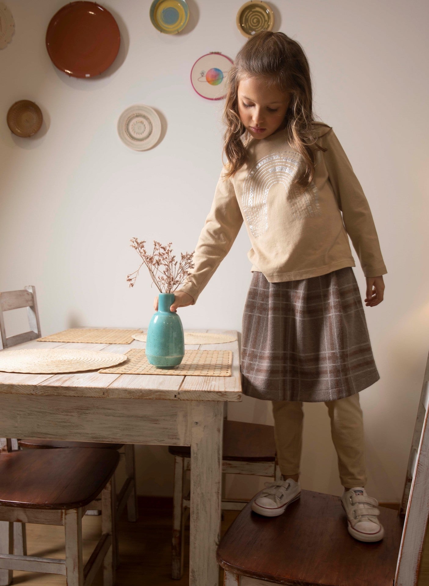 A long sleeve baby shirt in latte color featuring a chocolate rainbow print, made from 100% organic cotton.