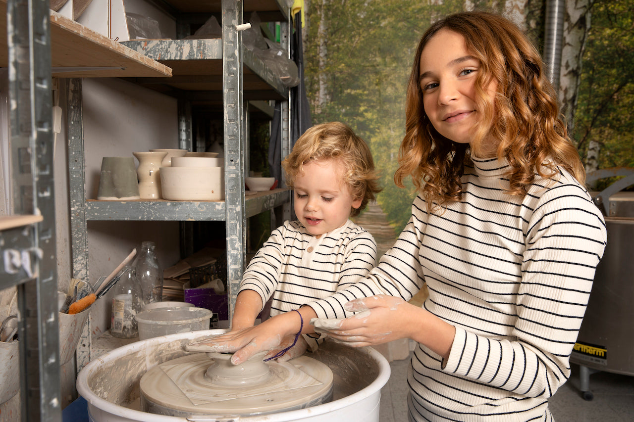 A soft, heather grey long sleeve shirt for babies and toddlers with a round collar and wood buttons, made from 100% organic cotton.