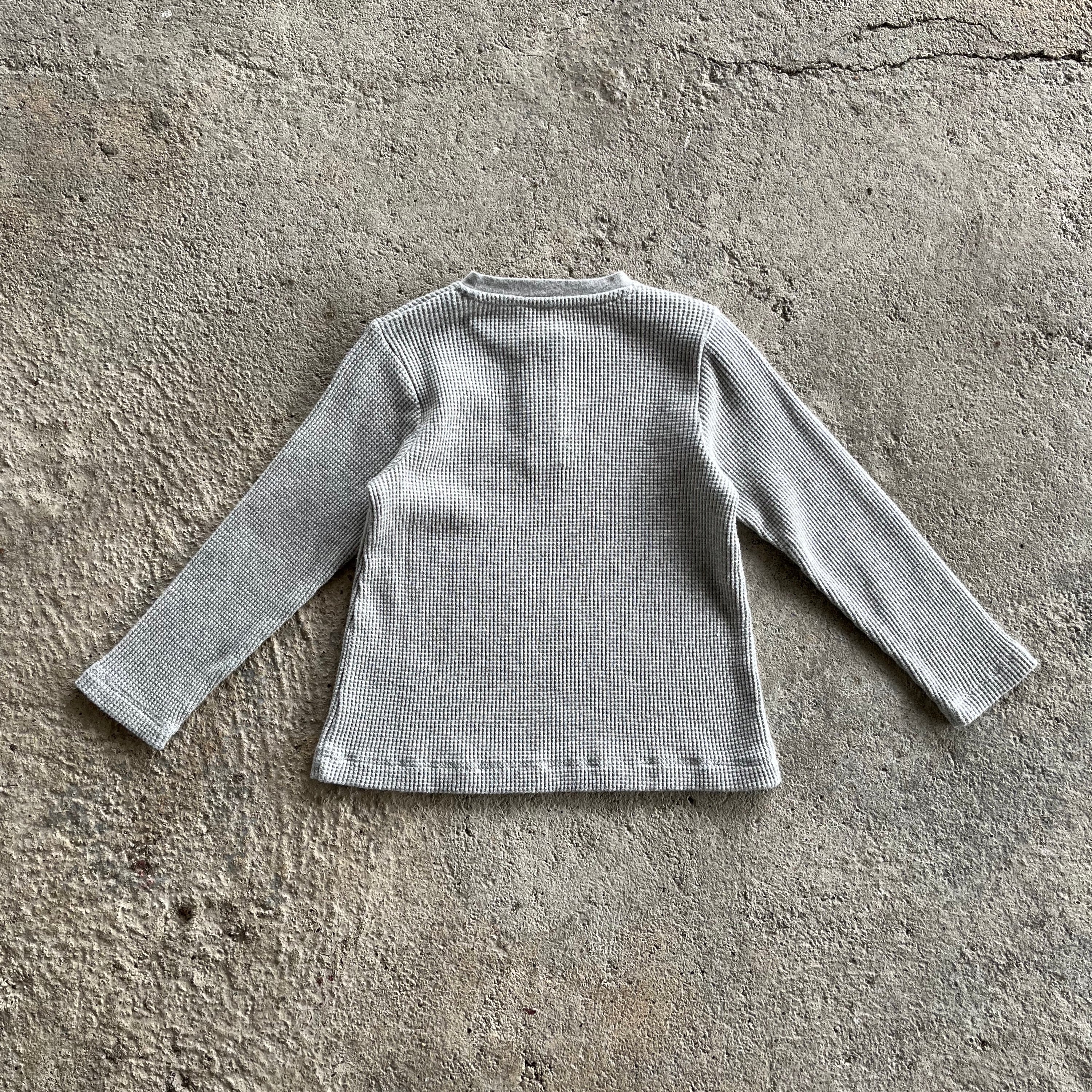 A soft, heather grey long sleeve shirt for babies and toddlers with a round collar and wood buttons, made from 100% organic cotton.