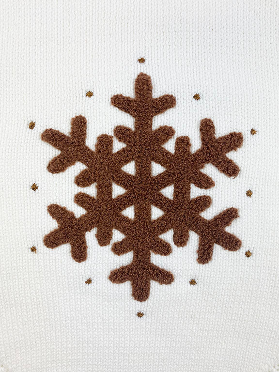 A cozy white knitted onesie for babies featuring a brown crochet snowflake design and wooden button details, perfect for holiday wear.