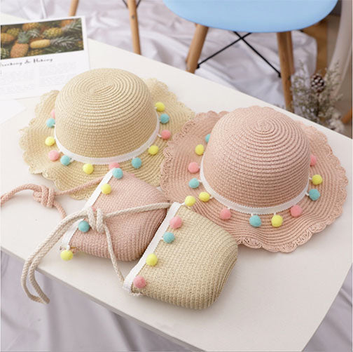 Adorable straw hat and purse set with multi-colored pom poms, perfect for spring outings for babies.