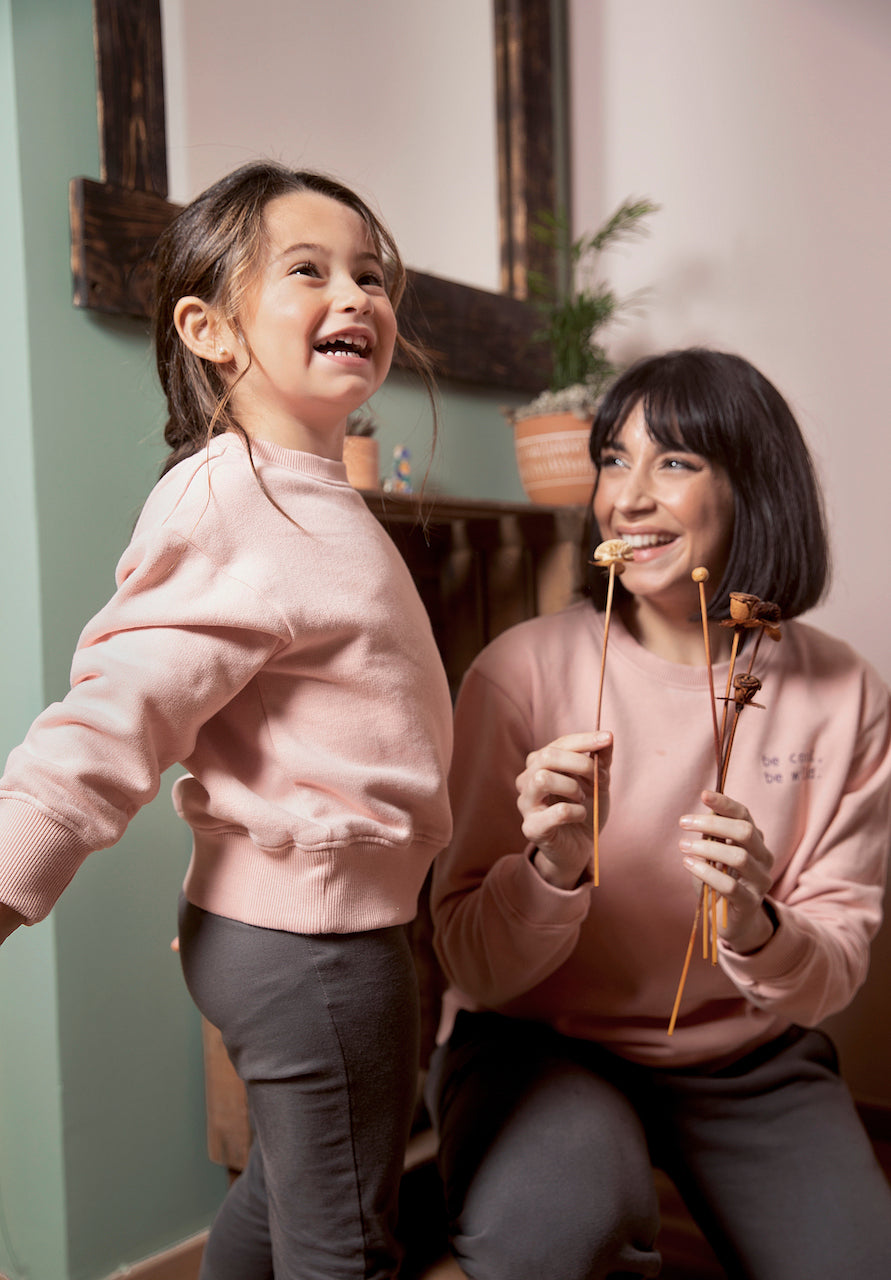 A vibrant pink sweatshirt for kids made from organic cotton, featuring ribbed cuffs and neckline with playful side embroidery.