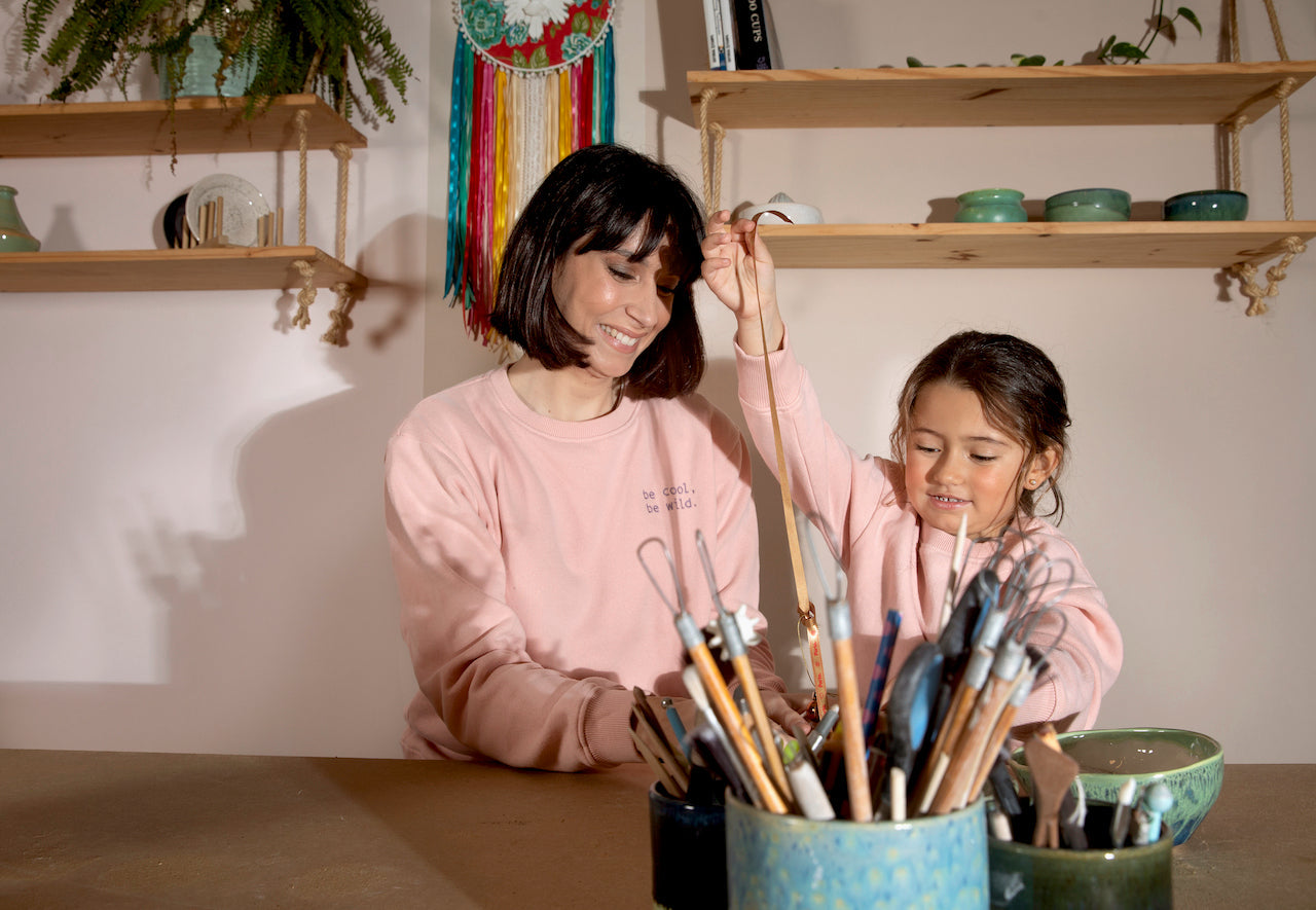 A vibrant pink sweatshirt for kids made from organic cotton, featuring ribbed cuffs and neckline with playful side embroidery.