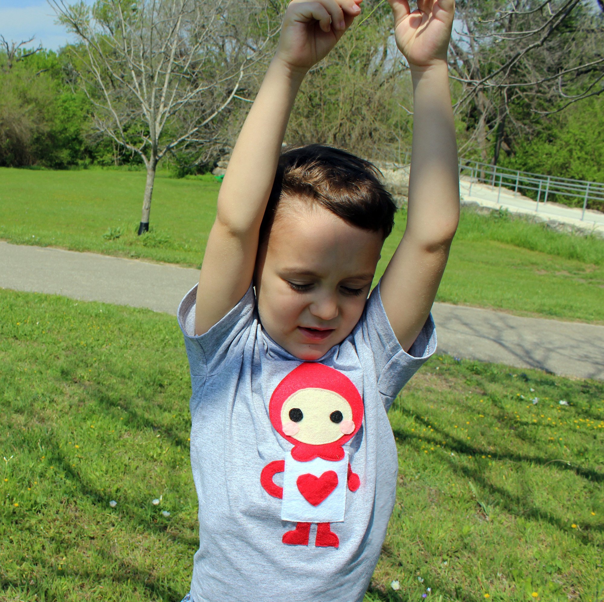 A colorful kids t-shirt featuring The Trumps Heart design inspired by Alice's Adventure in Wonderland, handmade with felt appliqué.