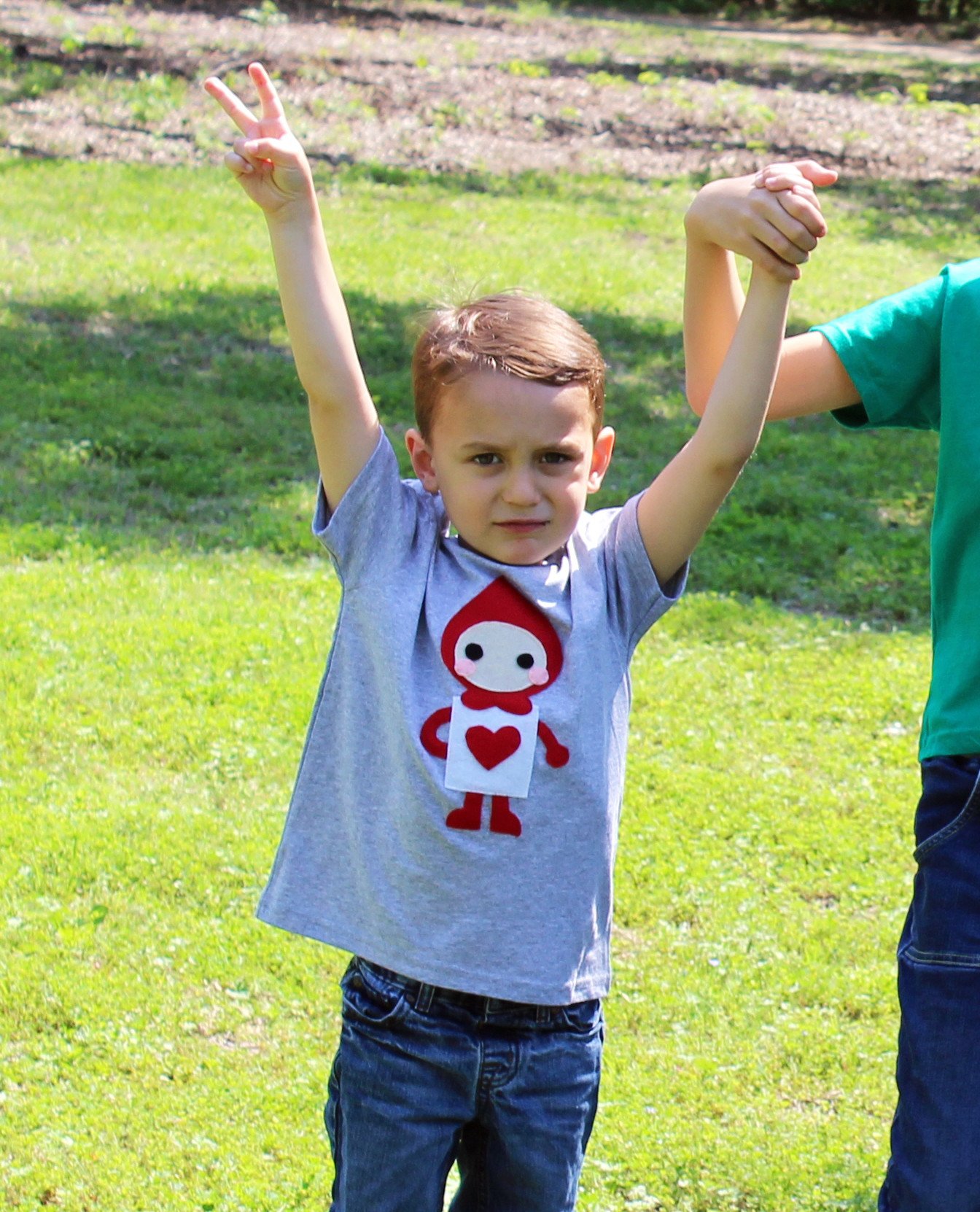 A colorful kids t-shirt featuring The Trumps Heart design inspired by Alice's Adventure in Wonderland, handmade with felt appliqué.