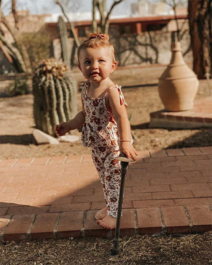 A stylish tie romper featuring an autumn floral print, designed with adjustable shoulder ties and double layer ruffles for added charm.