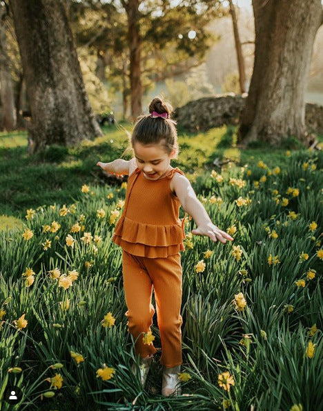 A stylish tie romper featuring an autumn floral print, designed with adjustable shoulder ties and double layer ruffles for added charm.