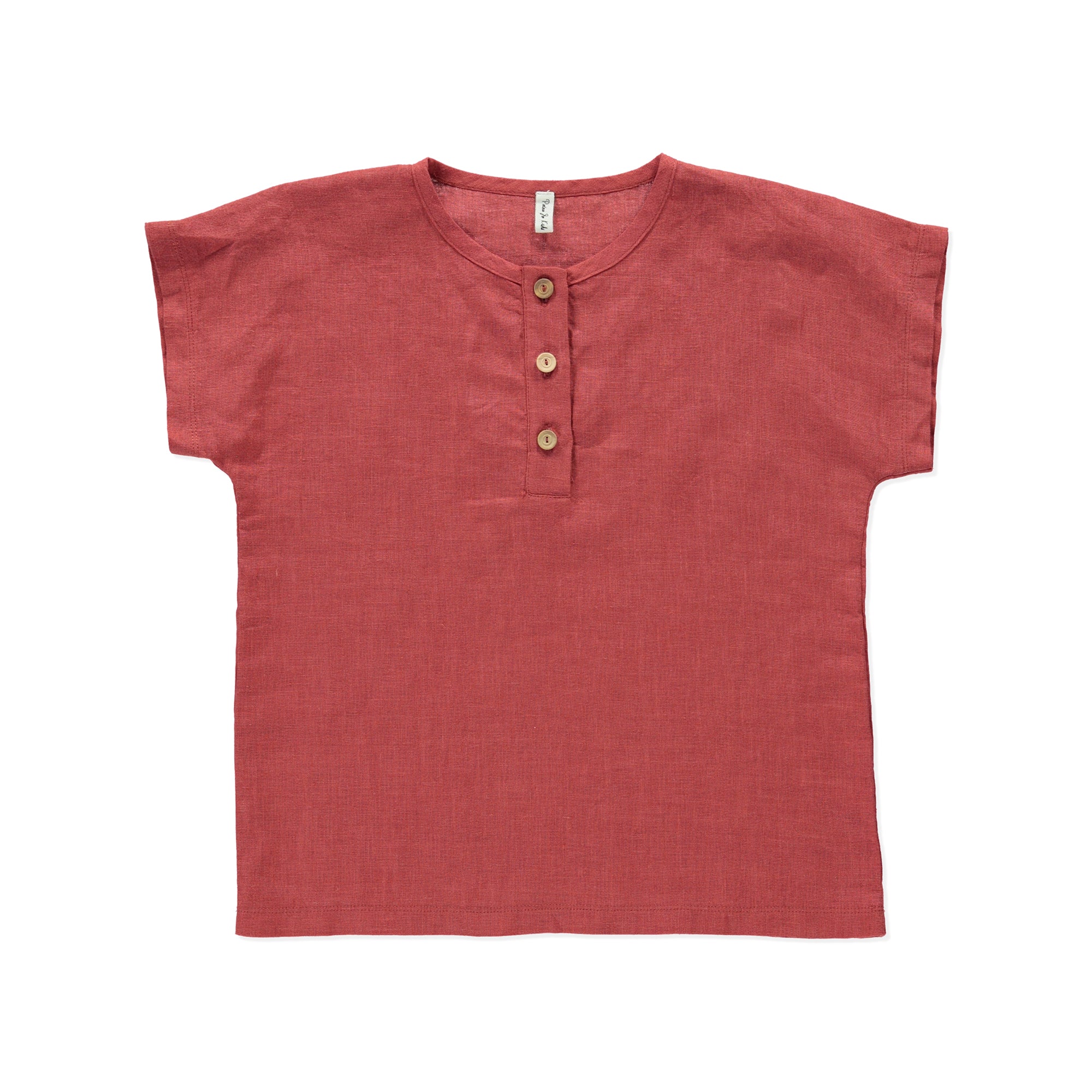 A casual boxy top in terracotta color made from 100% linen, featuring olive wood buttons at the front.