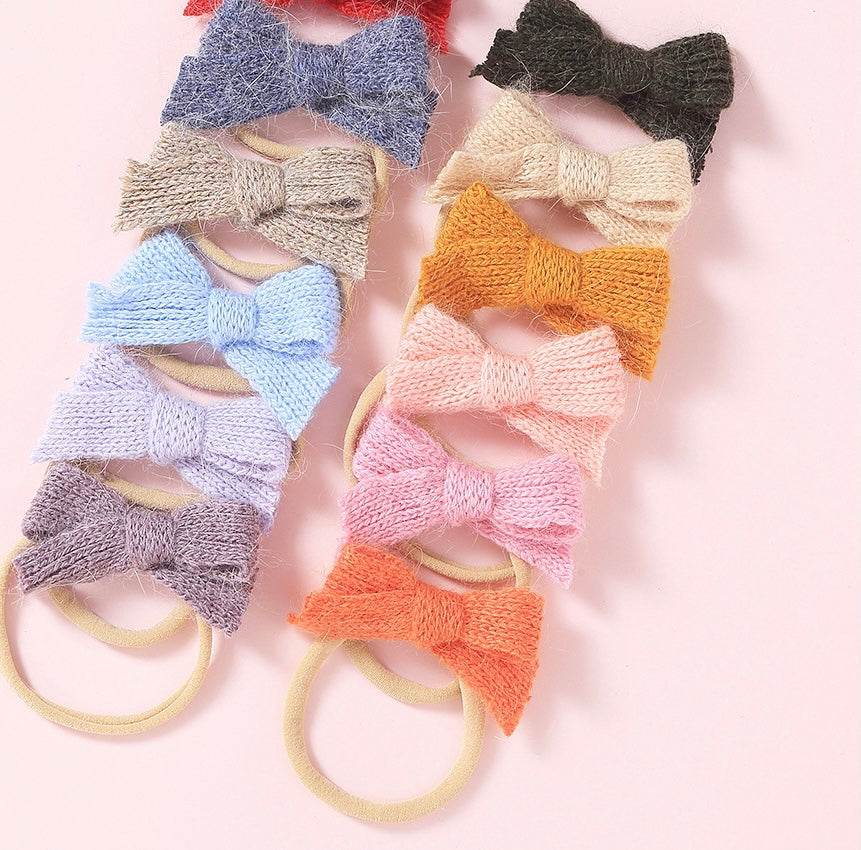 A cozy wool bow headband for babies, featuring a soft nylon band and a stylish 3-inch bow, available in multiple colors.