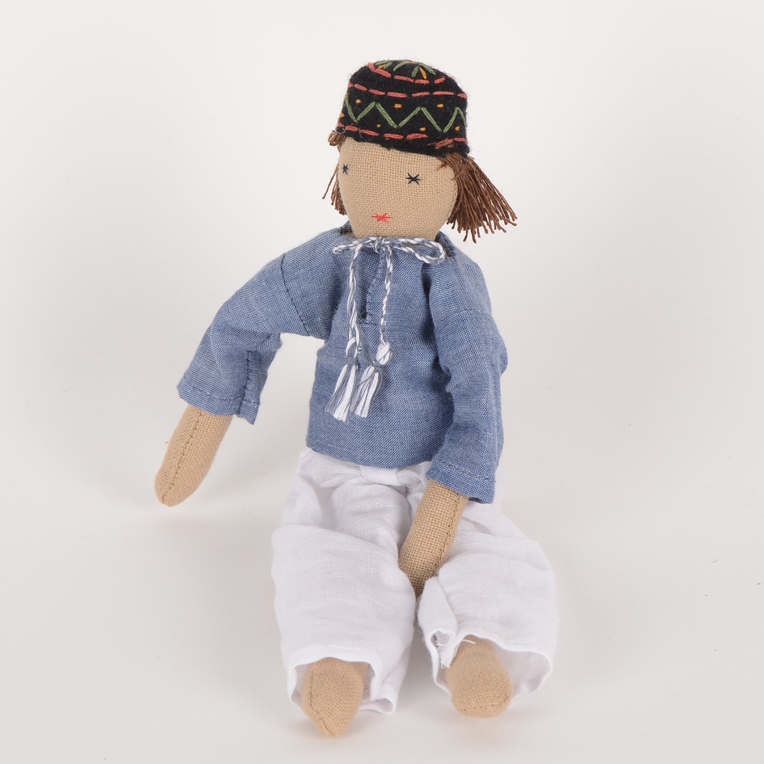 Ayu Mini Indian Baby Doll dressed in traditional kurta and pyjama, showcasing fine embroidery and woollen hair, with bedding in a foldable box.