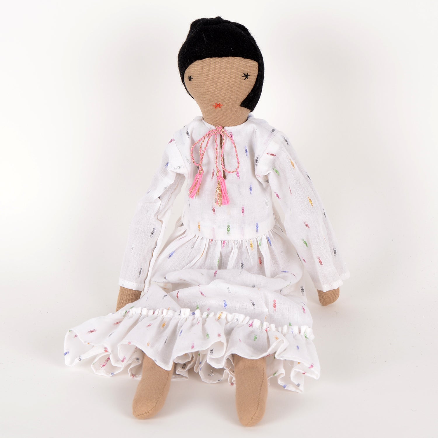 Calla, an elegant doll in a calf-length dress with frills, handcrafted by Afghan women, showcasing geometric motifs and woollen hair.