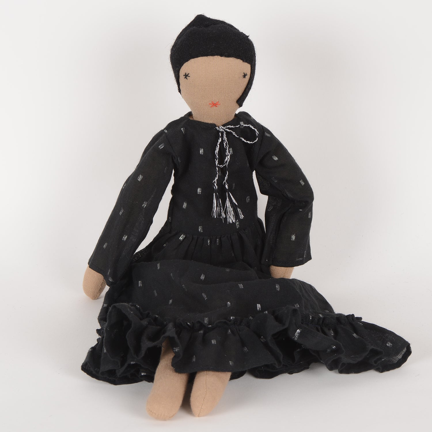 Calla, an elegant doll in a calf-length dress with frills, handcrafted by Afghan women, showcasing geometric motifs and woollen hair.