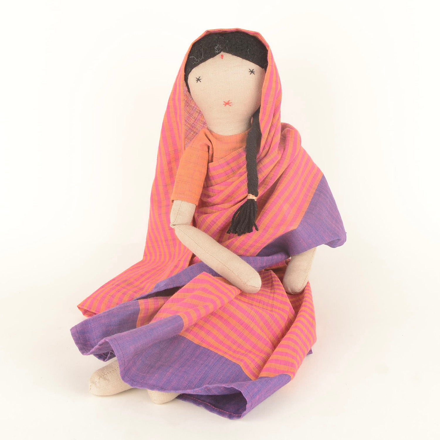 Chachi, the handcrafted doll in a colorful Indian sari, symbolizing joy and empowerment, with a bindi on her forehead and soft woollen hair.