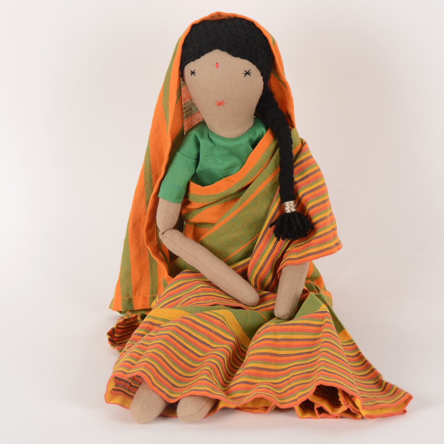 Chachi, the handcrafted doll in a colorful Indian sari, symbolizing joy and empowerment, with a bindi on her forehead and soft woollen hair.