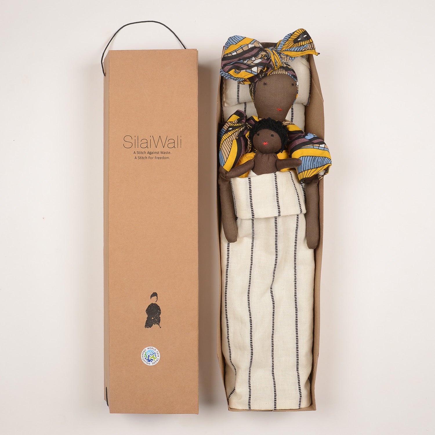 Imani doll with vibrant African print kaftan and regal turban, holding a baby, symbolizing maternal strength and cultural diversity.