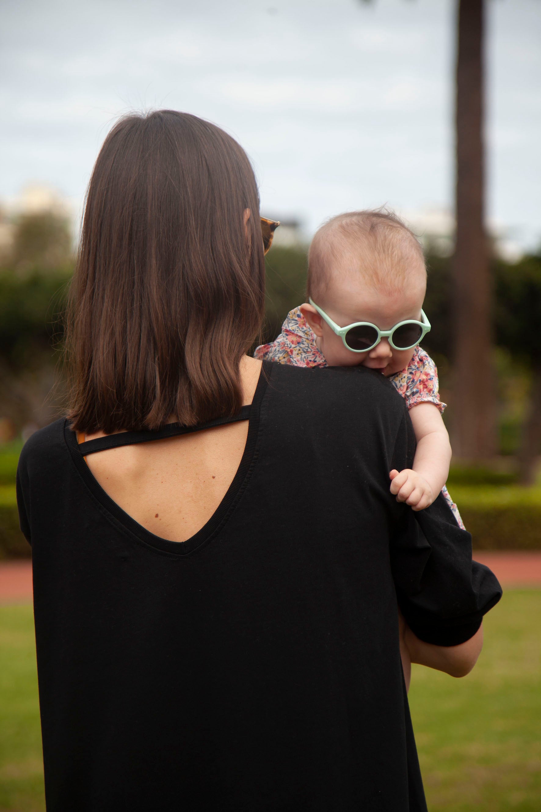 A stylish black breastfeeding dress with pink embroidery, featuring ruffles and YKK zippers for easy nursing access.