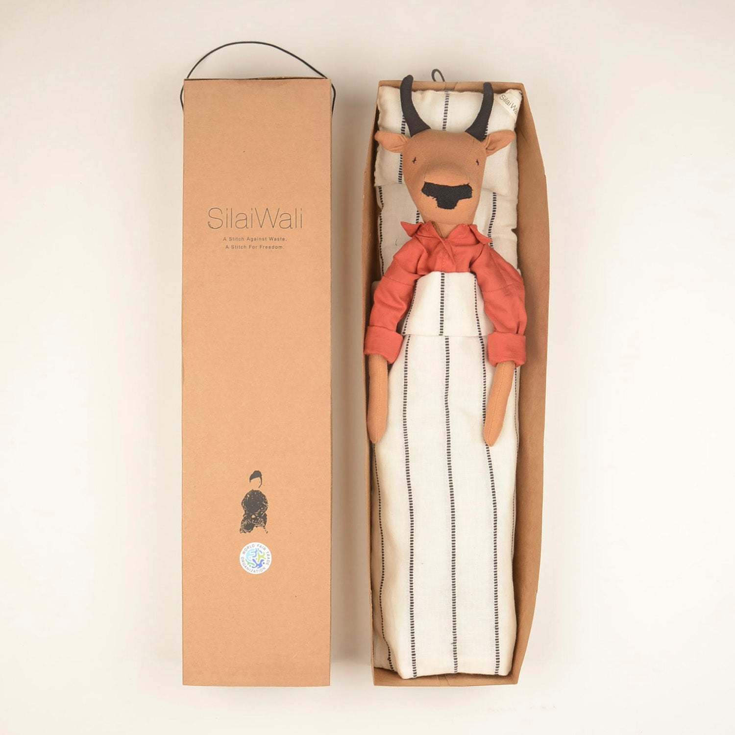 Handcrafted Nandi the Bull doll made from sustainable materials, featuring woollen hair and cotton bedding in a foldable box.