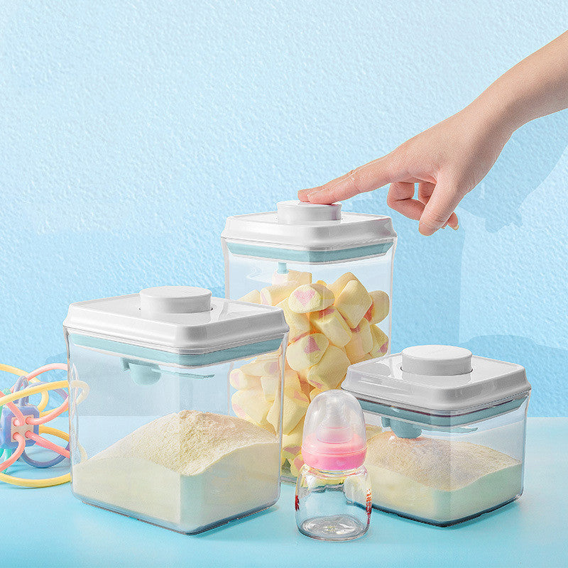 Transparent milk powder box with a one-key push-open lid, designed for moisture-proof storage and includes a hanging spoon for hygiene.