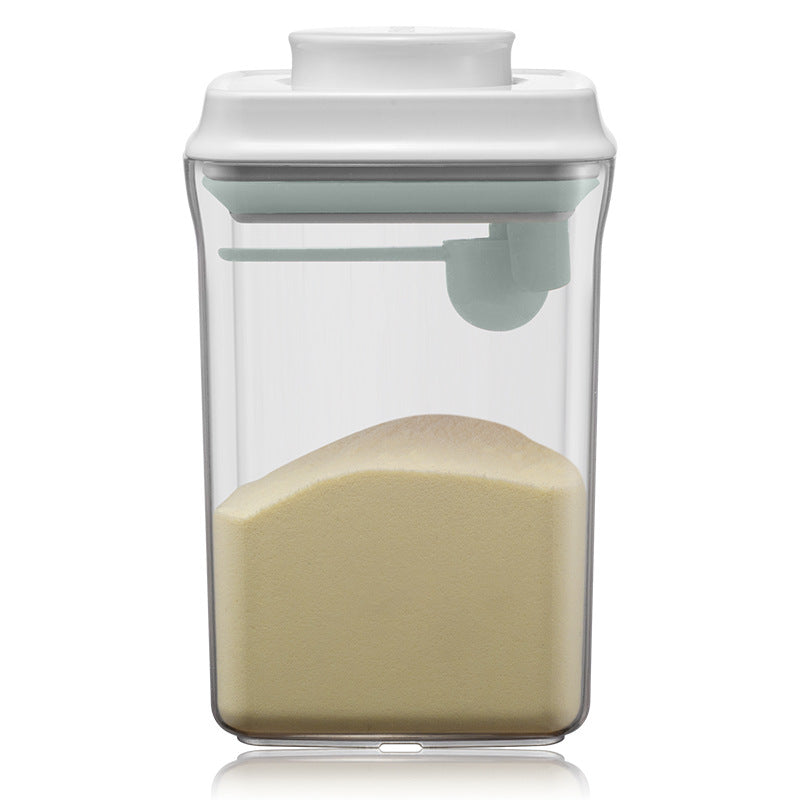 Transparent milk powder box with a one-key push-open lid, designed for moisture-proof storage and includes a hanging spoon for hygiene.