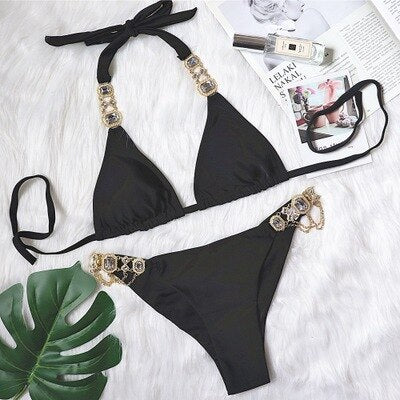 A luxurious women's bikini adorned with rhinestones and diamonds, featuring a low waist design and elegant style, perfect for beach outings.