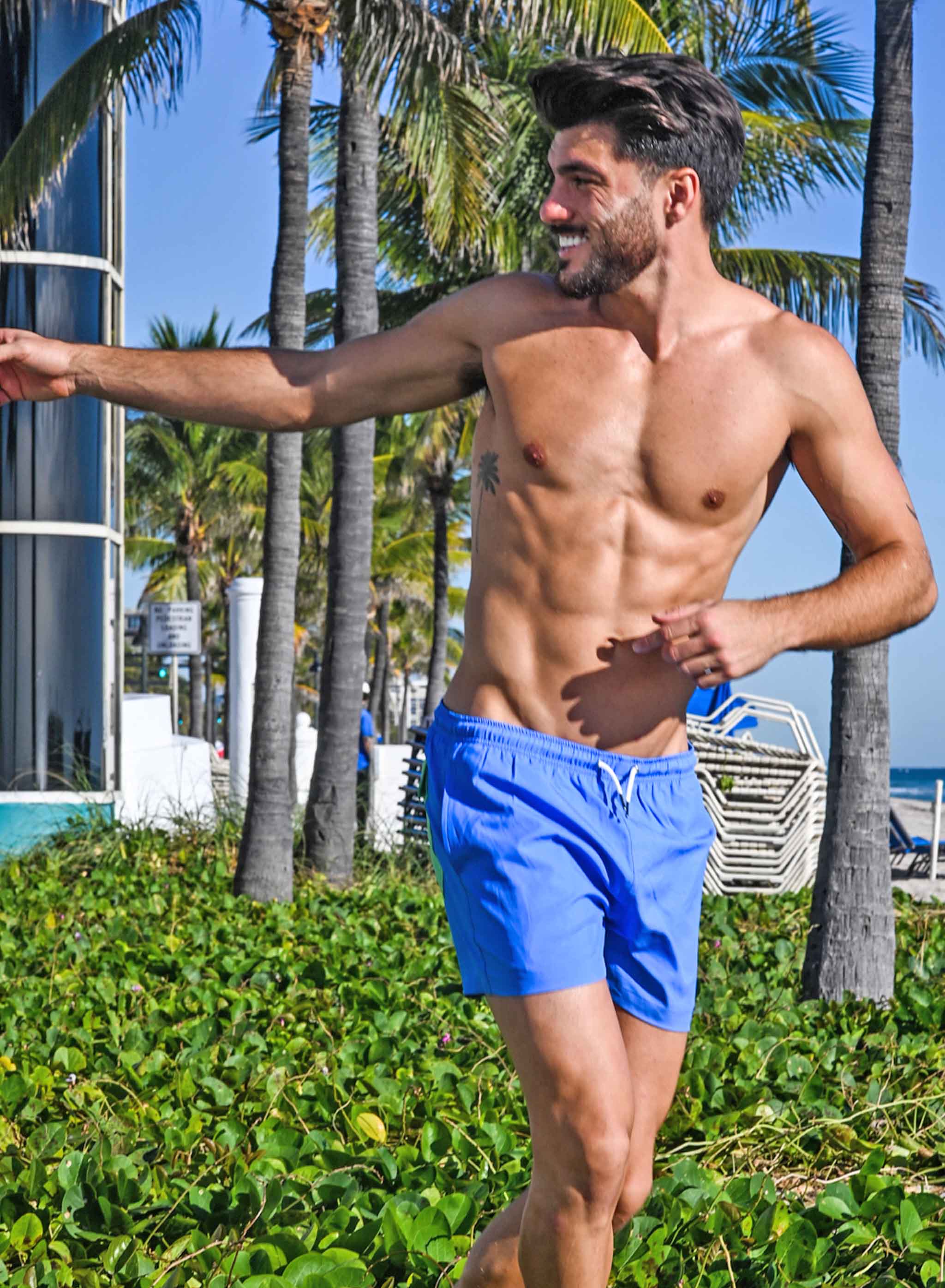 Blue swim trunks with green pocket, featuring a stylish design and eco-friendly materials.