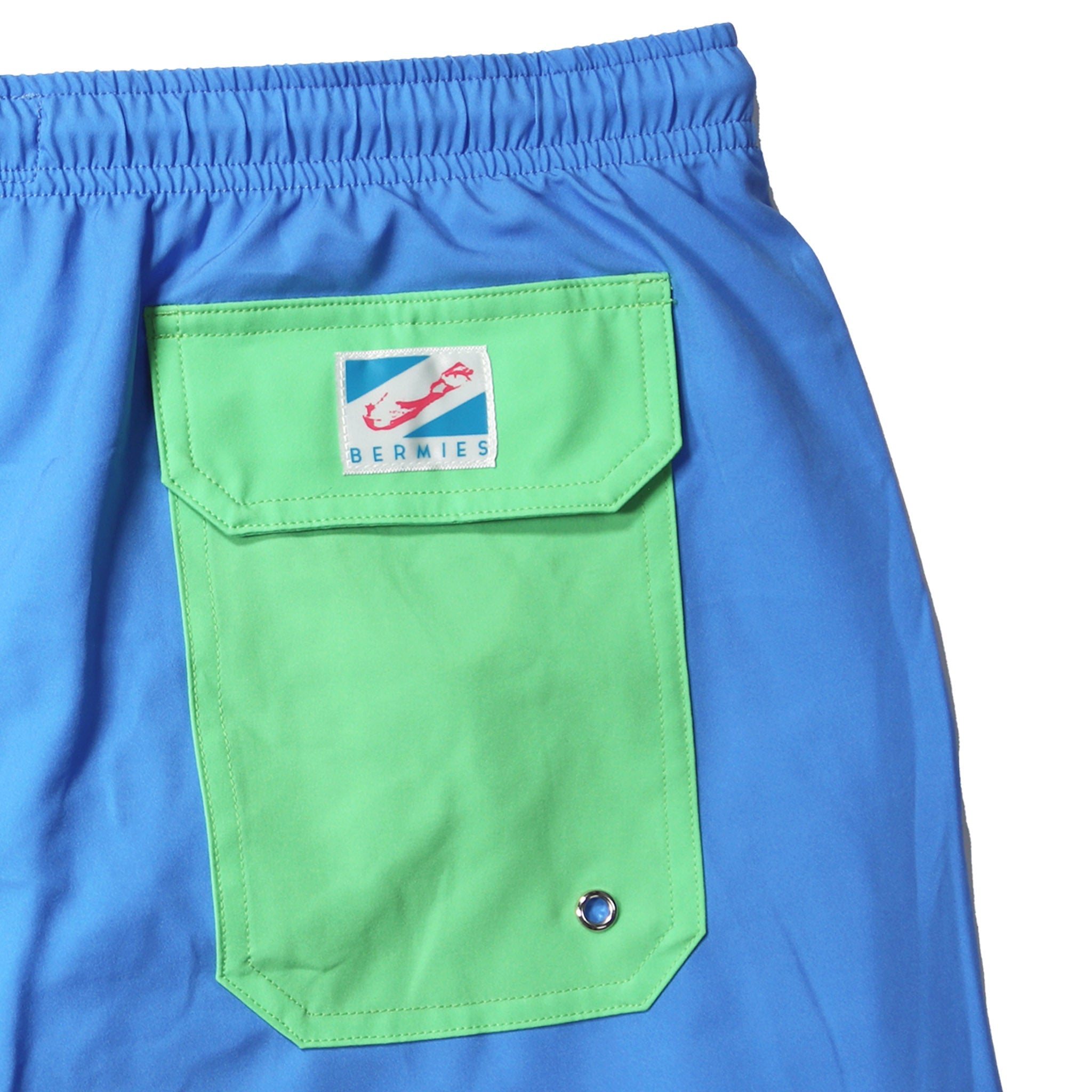 Blue swim trunks with green pocket, featuring a stylish design and eco-friendly materials.